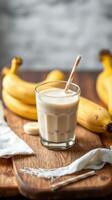 Refreshing banana smoothie served in a glass with ripe bananas on a wooden table in a cozy kitchen setting photo
