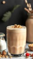Creamy nut milkshake topped with nuts and served in a glass on a stylish table setting photo