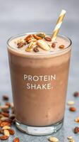 Delicious protein shake topped with nuts and oats, served in a clear glass with a striped straw photo
