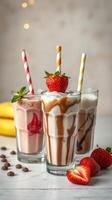 Colorful milkshakes with fresh strawberries and mint served in tall glasses on a light background photo