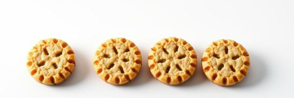 Delicious mini cookies arranged in a row on a white surface, showcasing their intricate design and golden color photo