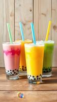 Colorful bubble tea drinks served in tall glasses on a wooden table in a cozy setting photo
