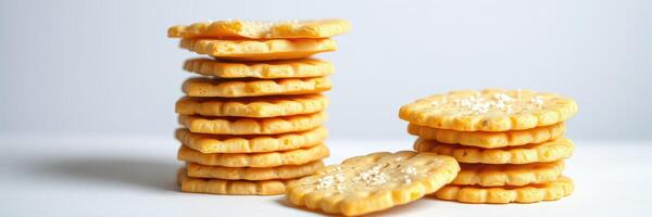 Stacked savory crackers arranged on a white surface with some scattered pieces photo