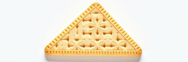 Triangular biscuit with intricate designs displayed on a light background photo