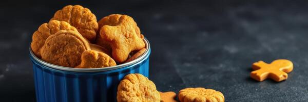 Delicious freshly baked cookies in a blue tin on a dark countertop with shapes of stars and gingerbread men photo