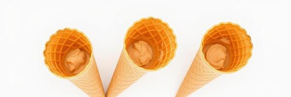 Three empty ice cream cones waiting to be filled on a plain white background photo