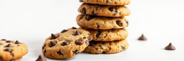 Freshly baked chocolate chip cookies stacked on a white background with scattered chocolate chips around photo