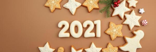Festive holiday cookies decorated with icing arranged around the year 2021 on a brown surface photo