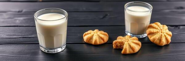 Delicious cookies paired with creamy milk on a dark wooden table photo