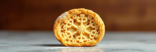 Delicate cookie with intricate design displayed on a marble surface in warm light photo