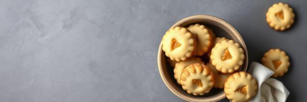 Freshly baked cookies displayed in a rustic bowl on a gray surface with a linen towel photo