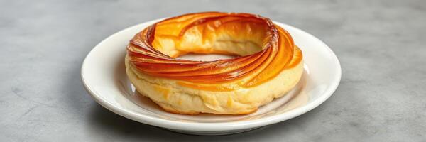 Freshly baked circular pastry served on a white plate in a cozy cafe setting photo