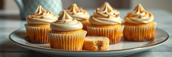 Delicious cupcakes with creamy frosting displayed on a plate beside a cookie in a cozy kitchen setting photo