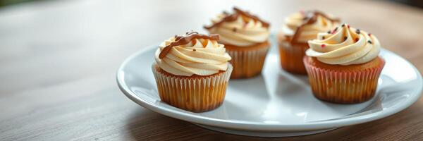 Freshly baked cupcakes with creamy frosting served on a white plate in a cozy kitchen setting photo