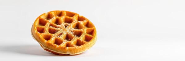 Waffle with a golden brown texture resting on a white surface ready to be served with toppings at breakfast time photo