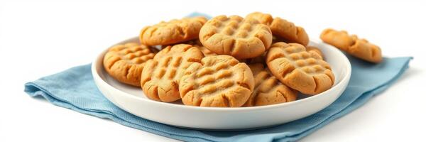 Freshly baked peanut butter cookies arranged neatly on a white plate with a blue cloth underneath photo