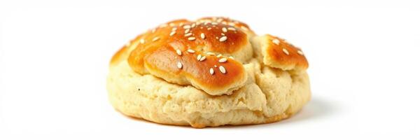 Freshly baked bread roll topped with sesame seeds on a clean surface photo