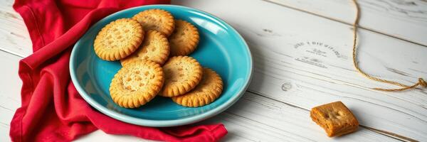 Cookies arranged on a blue plate with a red cloth in a cozy kitchen setting during daylight hours photo