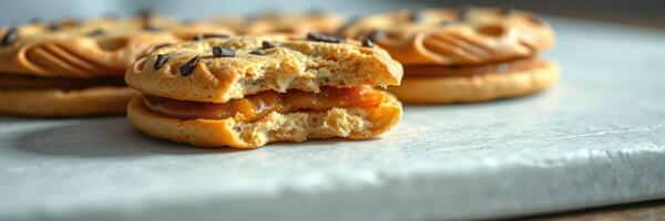 Delicious cookies filled with caramel and topped with chocolate sprinkles on a marble surface photo