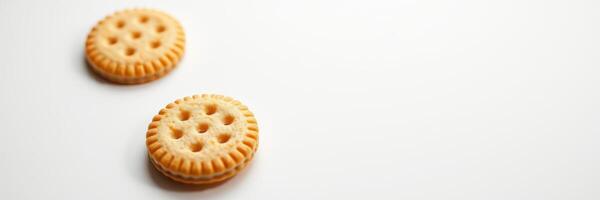 Two round cookies with a textured surface and cream filling on a plain background in a minimalist setting photo