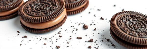 Delicious chocolate sandwich cookies with creamy filling and scattered crumbs on a white surface photo