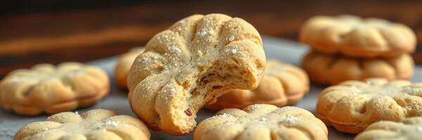 Handmade pumpkin-shaped cookies with a bite taken out, perfect for autumn treat displays at home or events photo