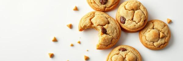 Freshly baked chocolate chip cookies arranged on a light surface with one cookie partially eaten photo
