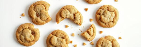 Delicious freshly baked cookies with a variety of shapes and bites scattered on a white surface photo