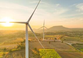 Wind farm field and sunset sky. Wind power. Sustainable, renewable energy. Wind turbines generate electricity. Sustainable development. Green technology for energy sustainability. Eco-friendly energy. photo