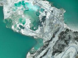 Open pit mine industry. Limestone quarry with backhoe and truck in operation. Heavy machinery in mining industry and construction material supply. Landscape of resource extraction in a industrial site photo
