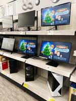 Kyiv, Ukraine - December 15, 2024 Display shelf showcasing monitors, computers, and promotional banners in a tech store photo