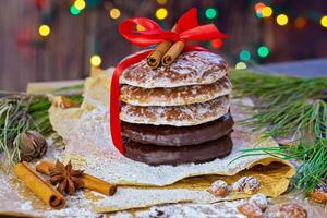 Festive Stack of Gingerbread Cookies with Red Ribbon and Cinnamon Sticks photo