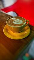 cup of yellow glass cappuccino coffee on the table photo