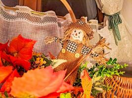 autumn composition with a small scarecrow standing on the window photo