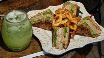 a plate of sandwiches and a drink on a table photo