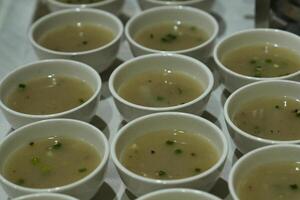 a tray of bowls with soup and green onions photo