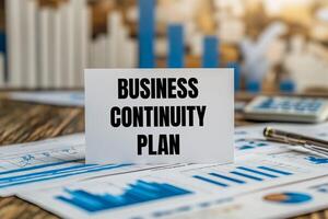 Business continuity plan message written on white paper card with financial charts and documents. Conceptual business continuity plan symbol. photo