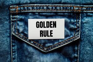 Golden rule message written on white card on denim jean background. Conceptual golden rule symbol. Copy space. photo