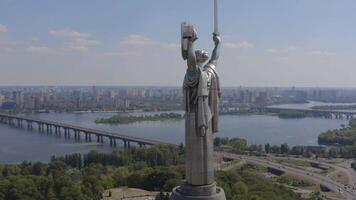 Aerial view of the monument of the statue of the Kyiv Motherland against the backdrop of the city of Kyiv, Ukraine. 4K video