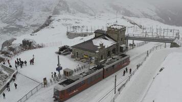 Aerial drone footage of the iconic cogwheel Gornergrat railway in the Zermatt ski resort in the Alps in Valais, Switzerland on a cloudy winter day video