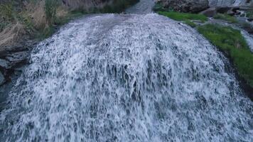 Waterfall in mountains, tourists travel through the mountains, stand at the cliff video
