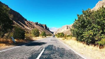 The car rushes at high speed along the mountain road past the trees video