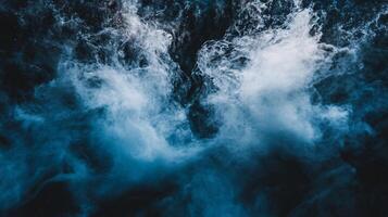 Large wave crashing into the ocean, creating a powerful and dynamic scene. The water is dark blue, and the wave is white, giving the impression of a stormy and intense moment photo