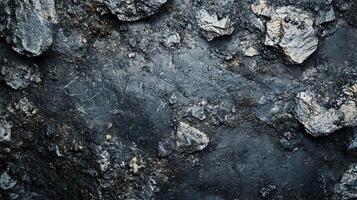 Rocky surface with a lot of dirt and debris. The rocks are scattered all over the ground, and the dirt is mixed in with them. Scene is rugged and untamed, with a sense of chaos and disorder photo