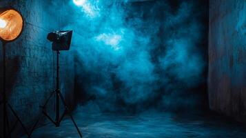 Dark room with a blue background and a light shining on it. The light is on a tripod and the room is filled with smoke photo