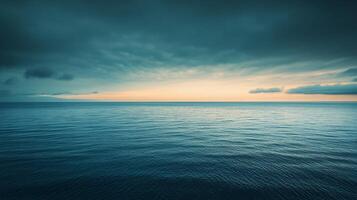 The ocean is calm and the sky is cloudy. The water is a deep blue color, and the sky is a mix of gray and blue. The clouds are scattered throughout the sky photo