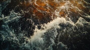 Wave crashing into the shore. The water is dark blue and the wave is white. Scene is powerful and dynamic, as the wave crashes into the shore with force photo