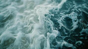 Body of water with foam and bubbles, creating a sense of movement and energy. The foam and bubbles are scattered throughout the water, giving it a dynamic and lively appearance photo