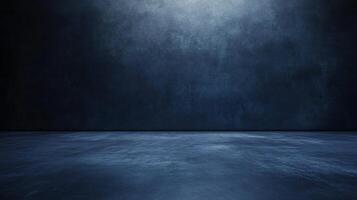 The room is a large, empty space with a blue wall. The walls are made of concrete and the floor is made of concrete as well. The room is completely bare and has no furniture or decorations photo