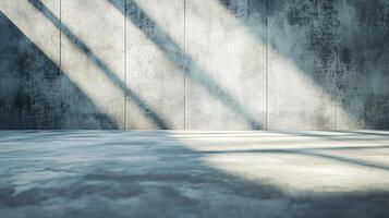 Large empty room with a wall that is covered in cracks. The wall is grey and the floor is grey as well. There is a window in the room that is letting in sunlight photo